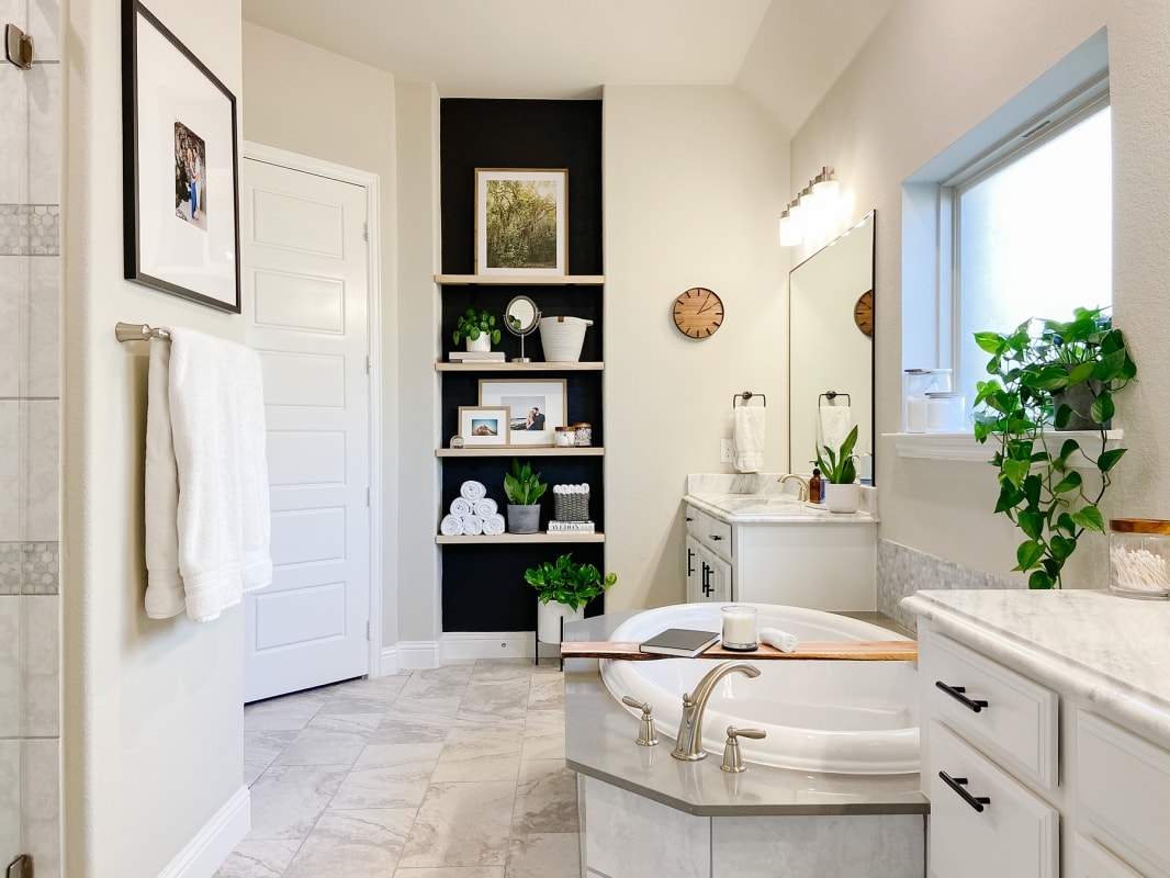 Modern bathroom with black accent wall and freestanding soaking tub